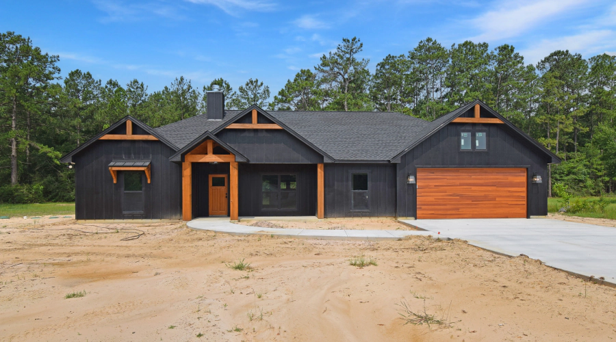 black house with wooden garage door and doors