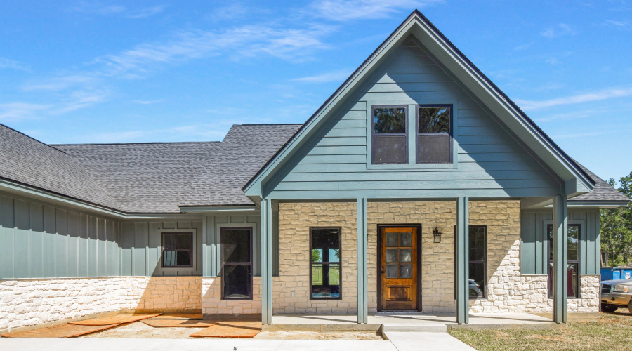 blue house with stoned walls and a patio around